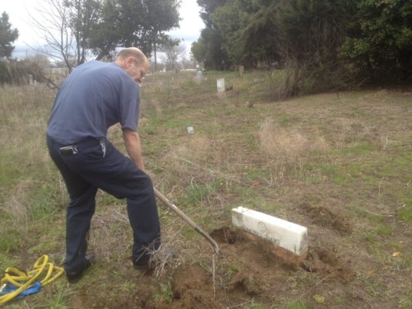 Robert Birdsong digging out the headstone of Henry Sims