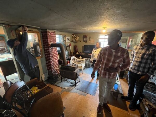 Dr. West takes digital photographs of the attic while Mr. Morganfield, Dr. Momon, and Dr. Ajibola look on (Photo: © T. DeWayne Moore, 2023)